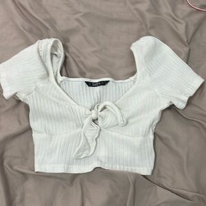 White crop top with a bow in front of